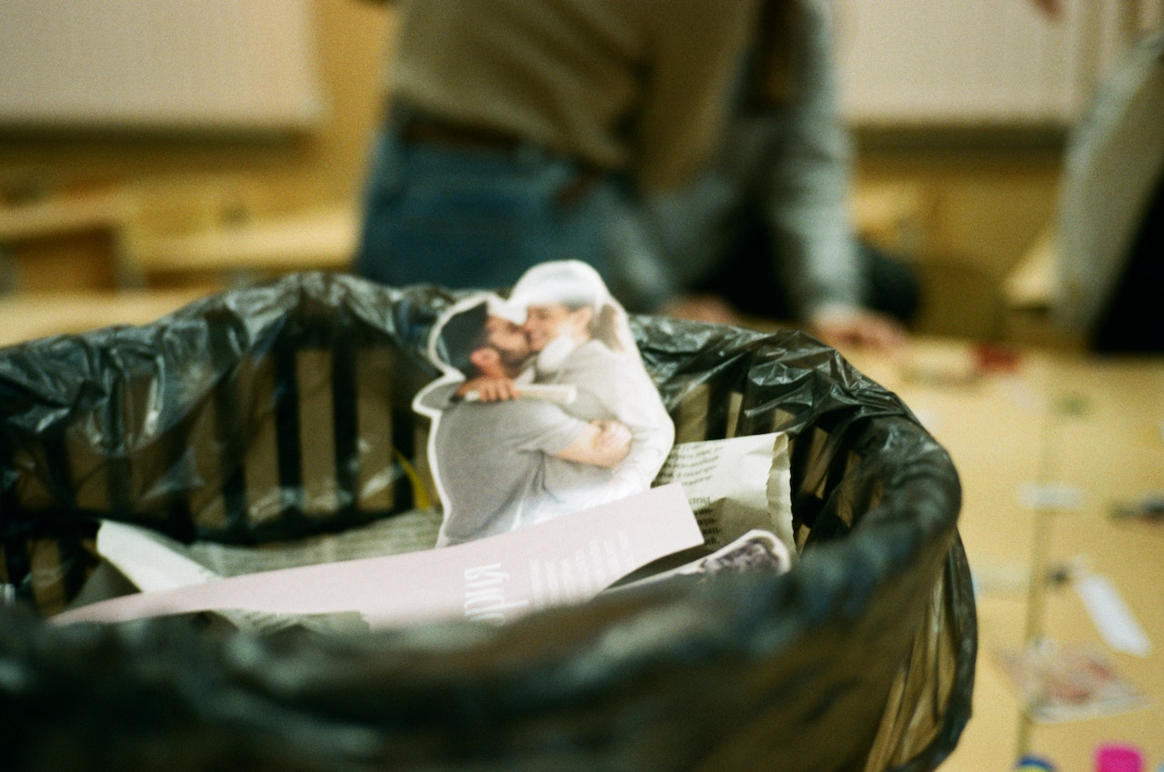 photo of couple kissing in trash bin